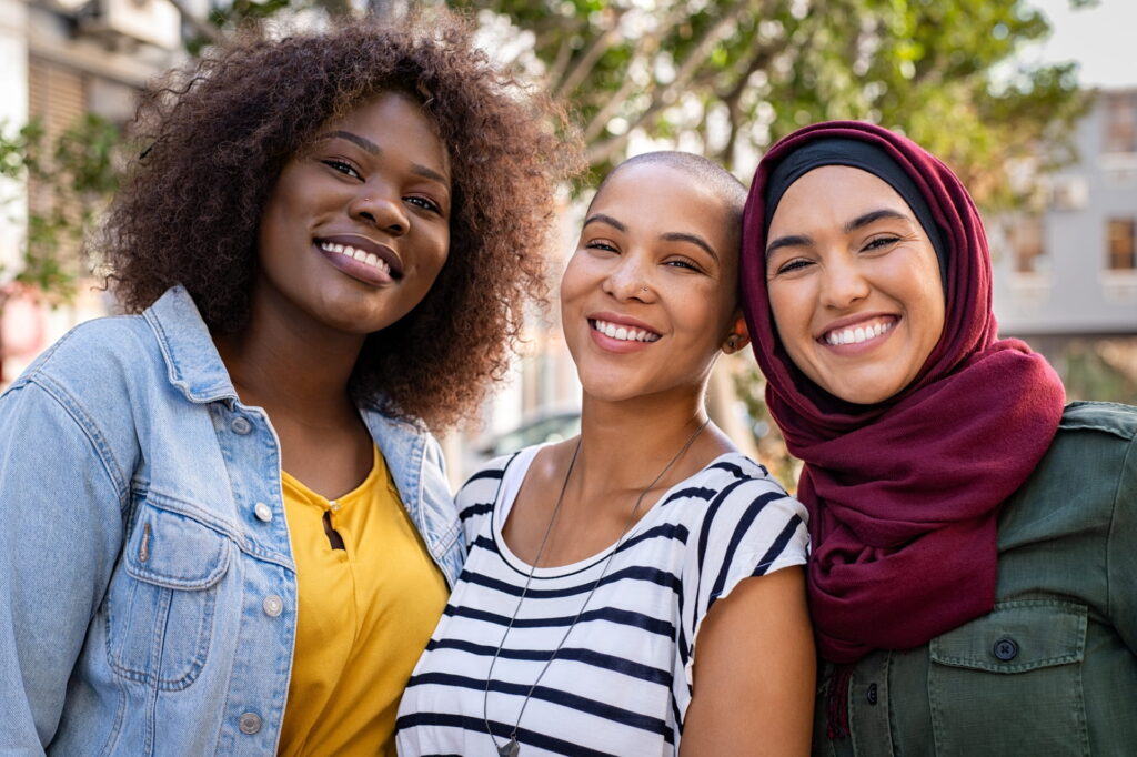 Three young women smiling together outdoors