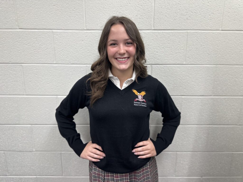 Kennedy Catholic student posing in front of a white brick wall.